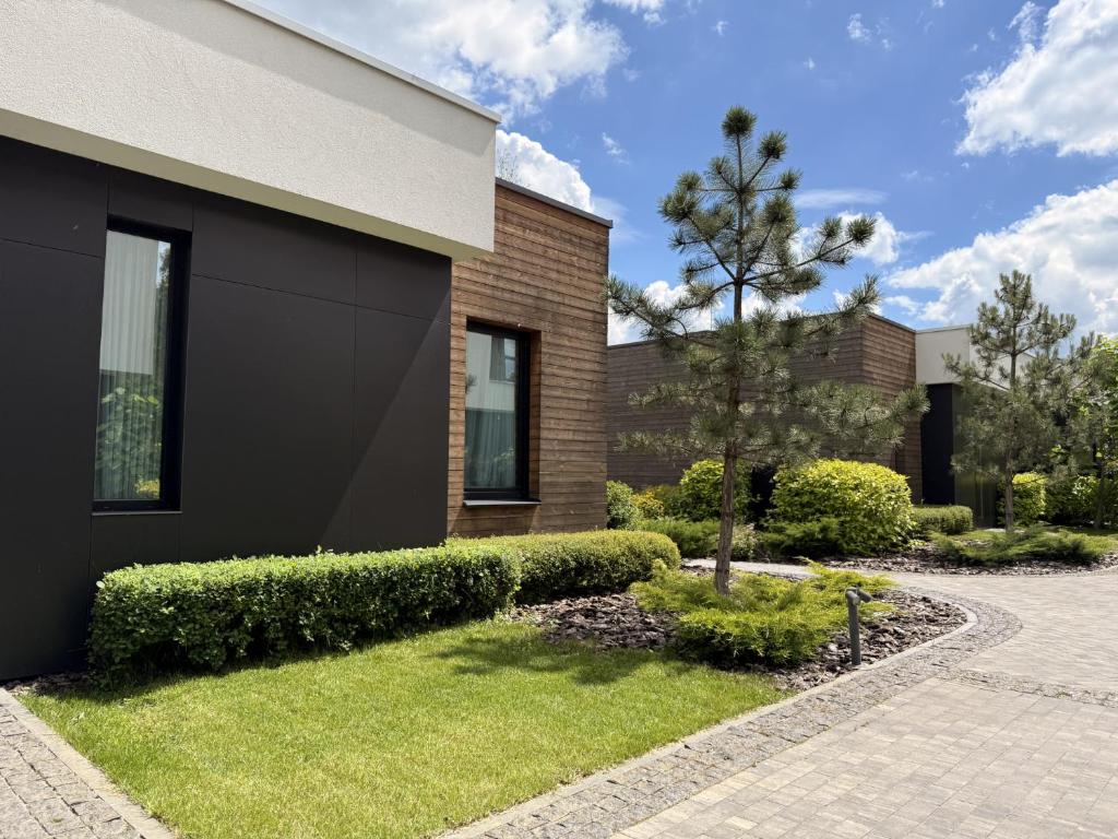 a brick house with a tree in the front yard at Lakes Places Villas in Kyiv