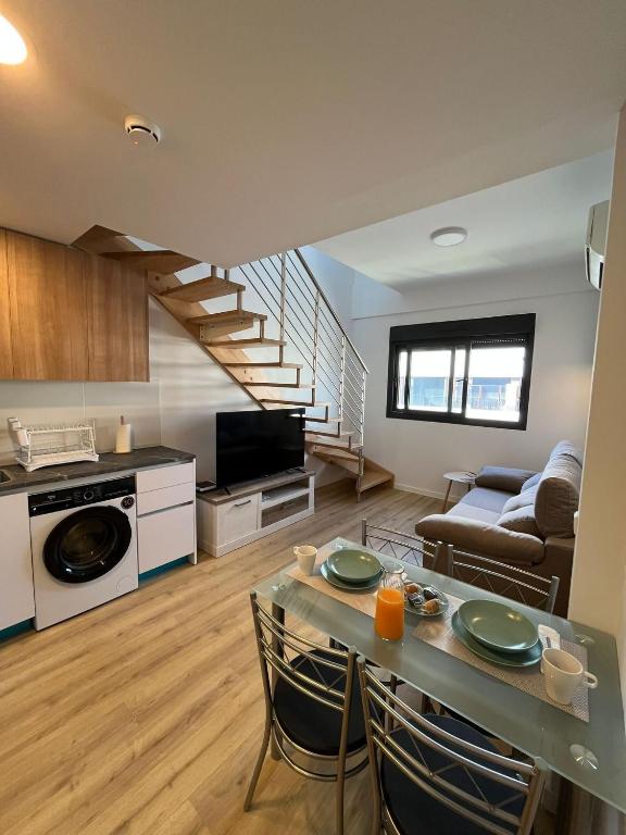 a kitchen and living room with a table and a couch at A&R Atico Duplex Luxury I in San Sebastián de los Reyes