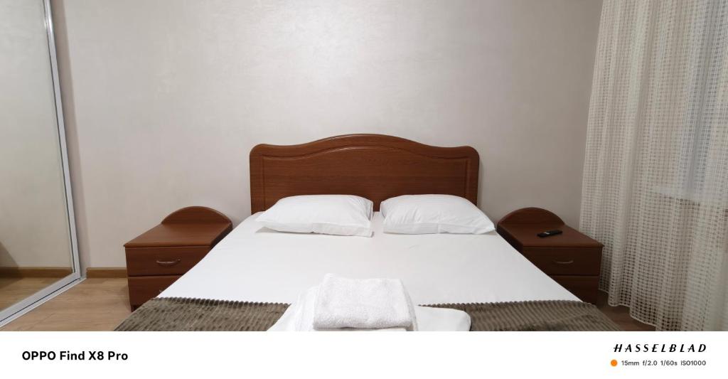 a bedroom with a bed with white sheets and pillows at Buiucani Apartament Chișinău in Chişinău