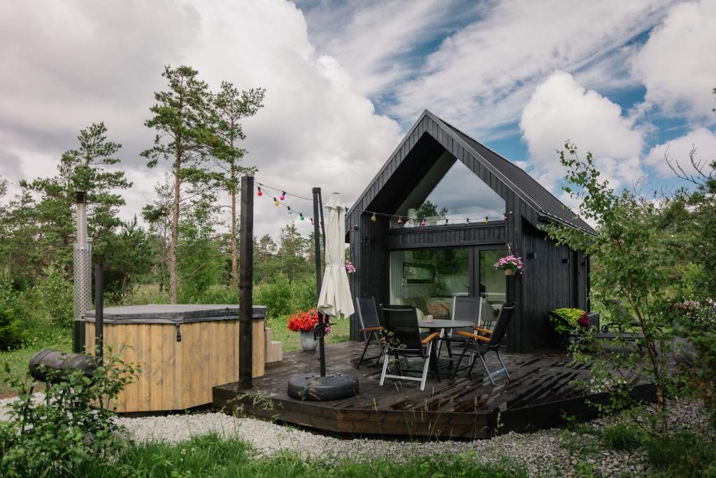 a black tiny house with a table and chairs at Majakavahi in Sääre