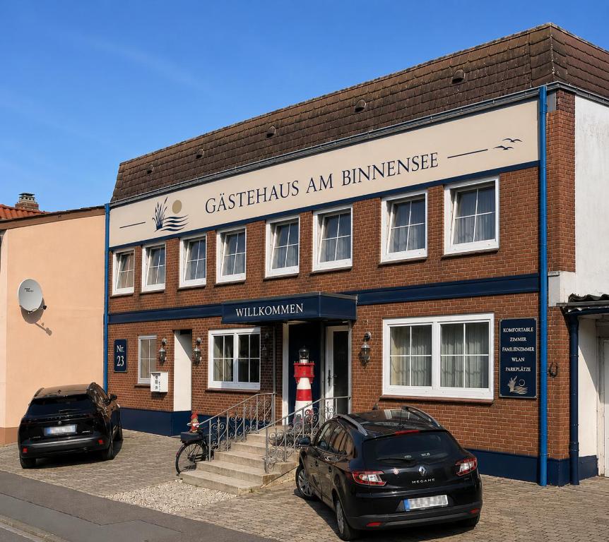 two cars parked in front of a brick building at Gästehaus am Binnensee in Heiligenhafen
