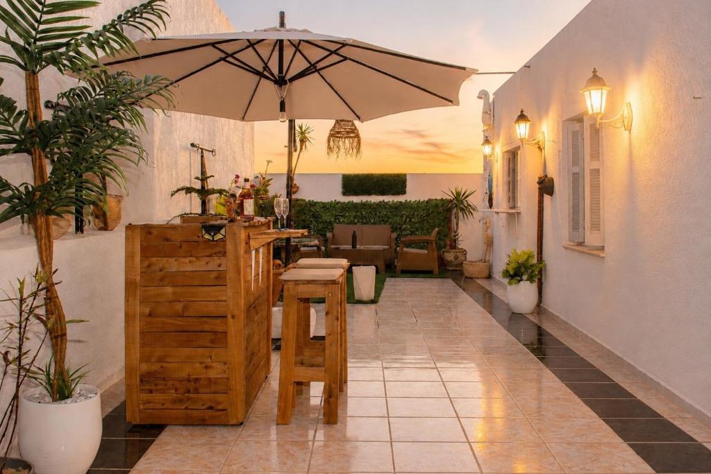 a patio with a table and an umbrella at Le Rooftop Apparte - Barbecue, Grande Terrasse in Nabeul