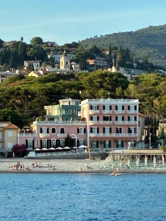 a group of people on a beach in the water at Hotel Piccolo Lido in Bordighera