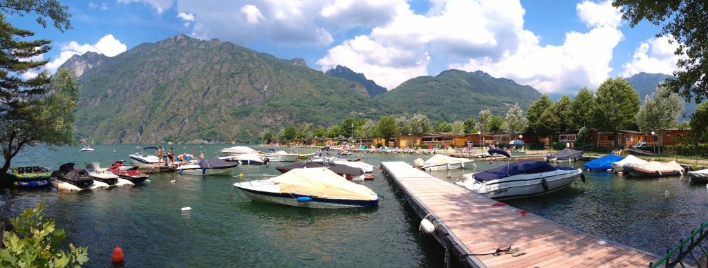eine Gruppe von Booten, die an einem Dock im Wasser angedockt sind in der Unterkunft Sunwaychalets Lago di Lugano in Porlezza
