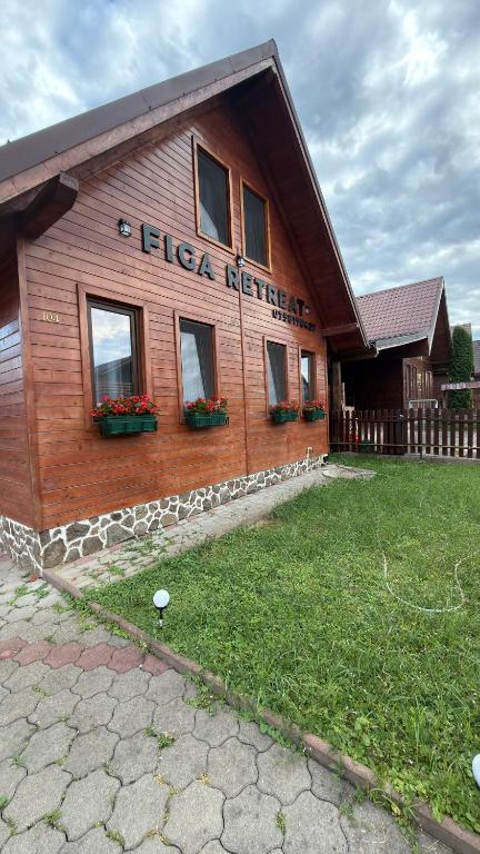 a wooden building with flowers on the side of it at Figa Retreat in Beclean