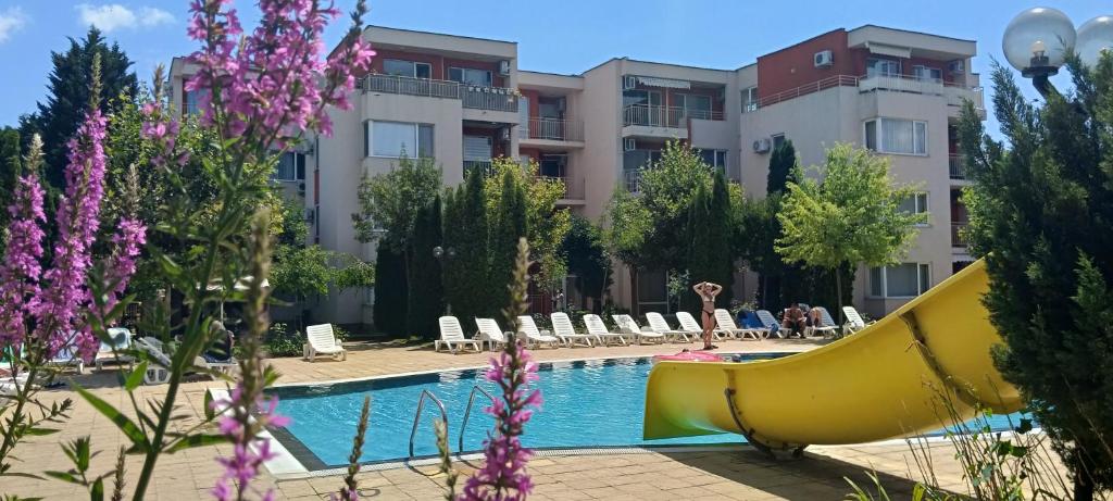 a pool with a slide in front of a building at Sea Breeze Studio at Fort Noks Resort in Sunny Beach