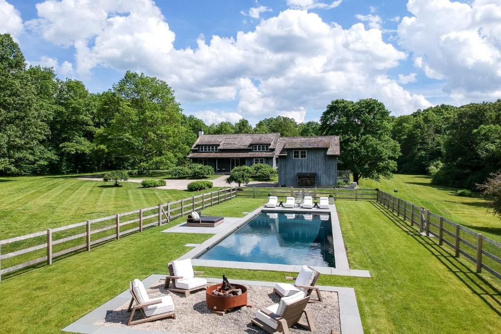 a backyard with a swimming pool and a house at Whimsy Woods - 14 Acre Millbrook Estate with Pool in Millbrook