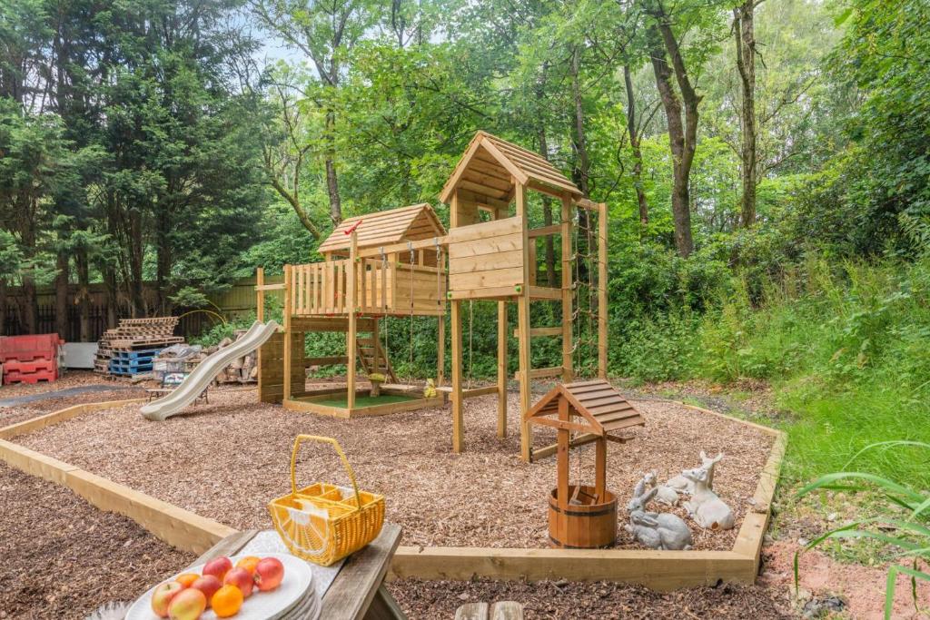 a playground with a tree house and a slide at 3 Bed in Blackburn oc-96386 in Blackburn