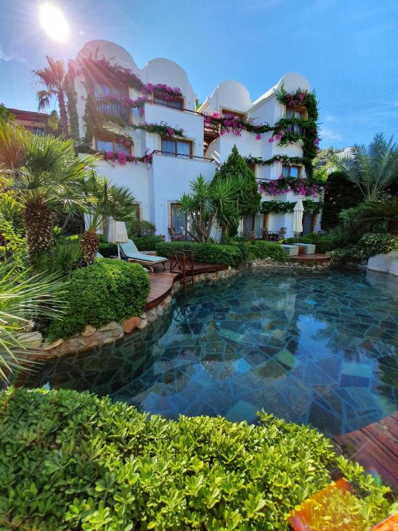 a hotel with a swimming pool in front of a building at Munahan Otel in Bodrum City