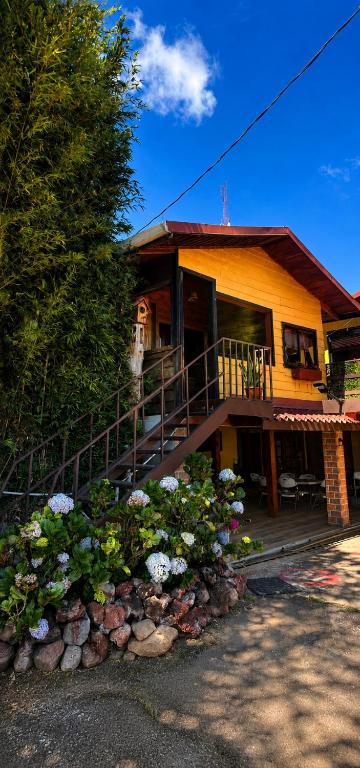 a house with a bunch of flowers in front of it at Chalet Rústico para parejas in Alajuela