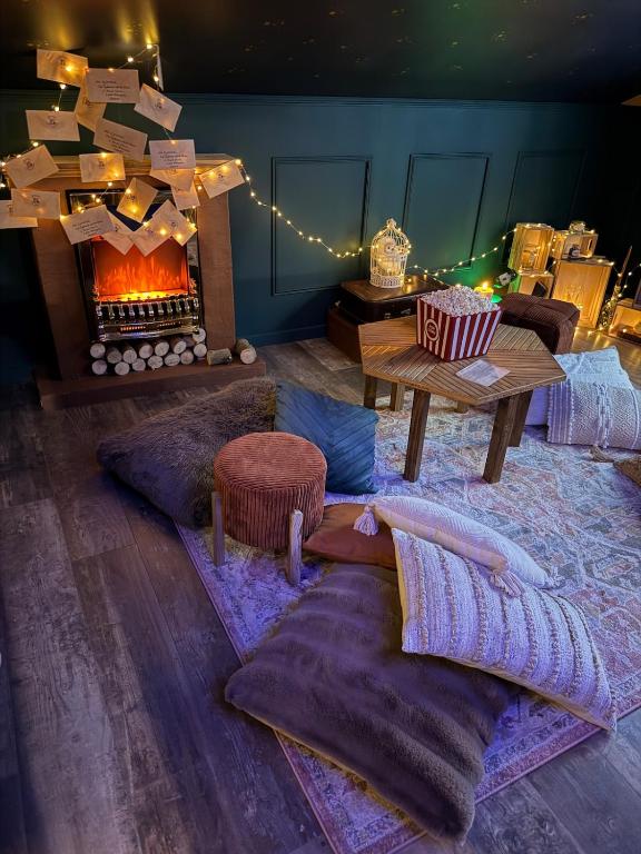 a living room with a fireplace and a table with pillows at Le grenier des sorciers in Balbigny