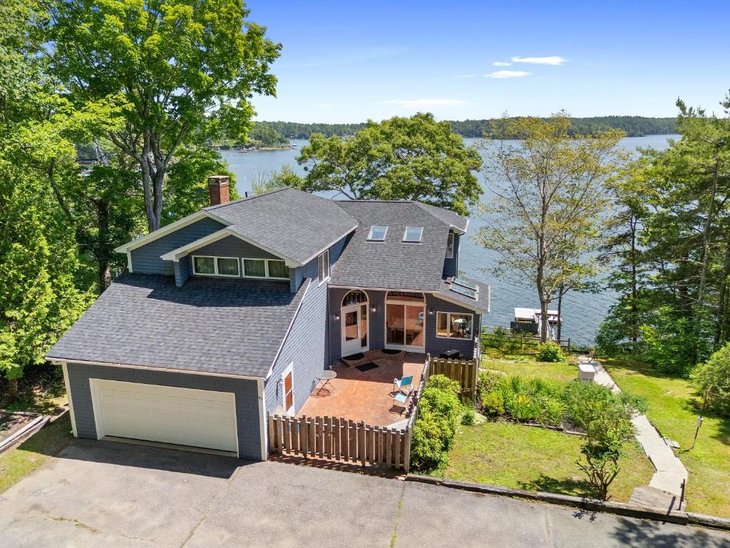 an aerial view of a house with a lake at Serene waterfront home w/ a dock, large deck & amazing views! in Dyer Cove