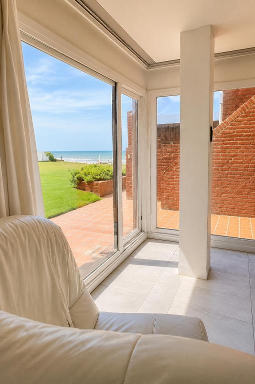 a room with a bed and a large window at Despertá frente al mar! Loft con bajada privada! in Santa Clara del Mar
