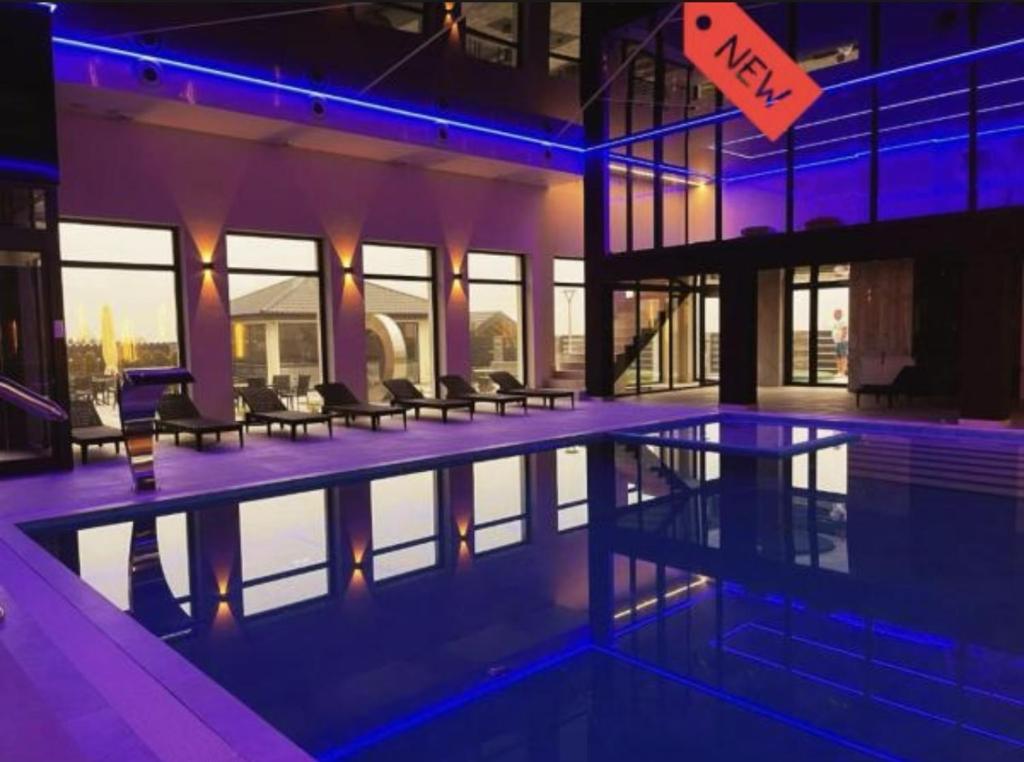 a building with a swimming pool with blue lights at Holiday Home Resort & Spa in Jarosławiec