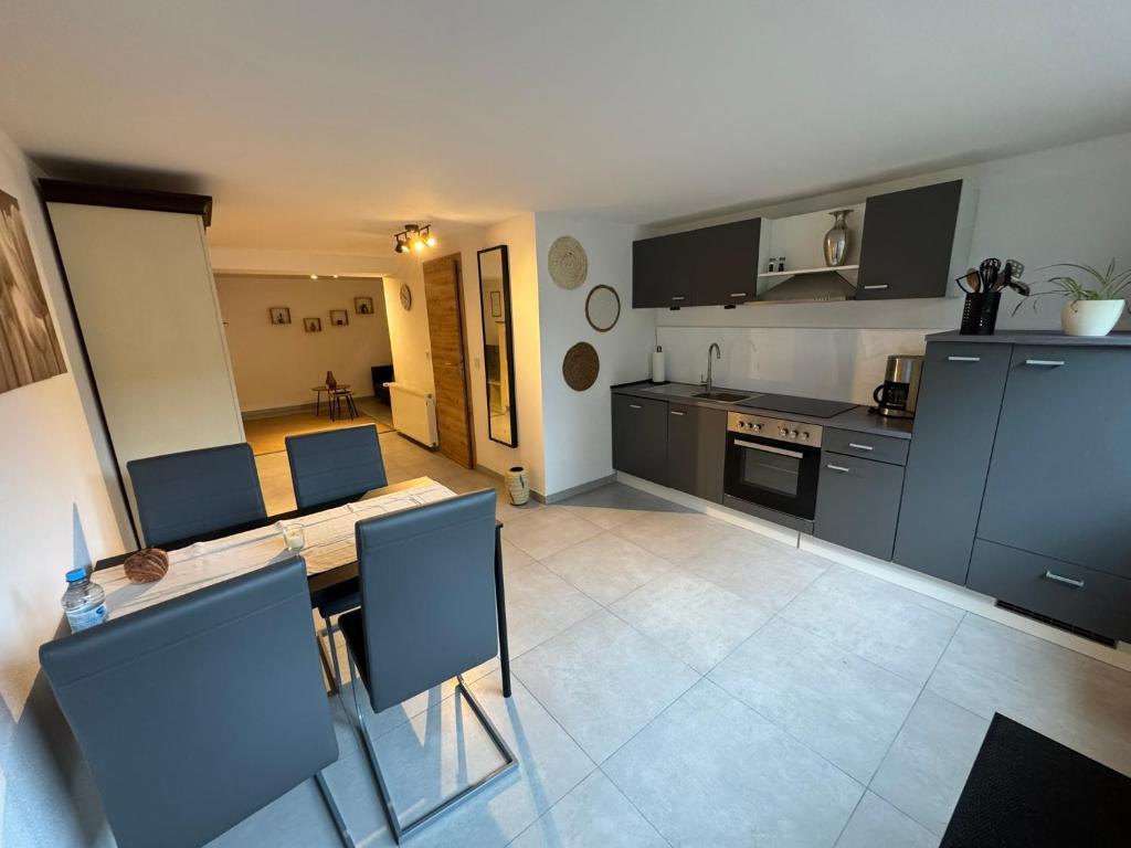 a kitchen with a table and chairs in a room at Toms FeWo in Losheim