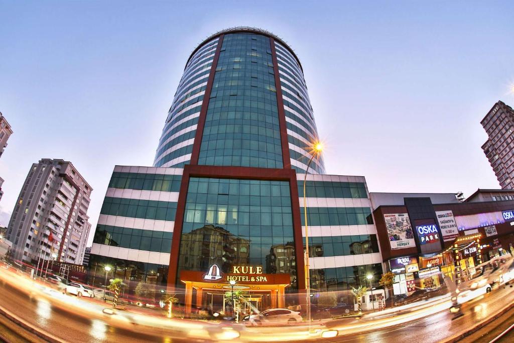 a tall glass building with a street in front of it at Kule Hotel&Spa Gaziantep in Şahinbey
