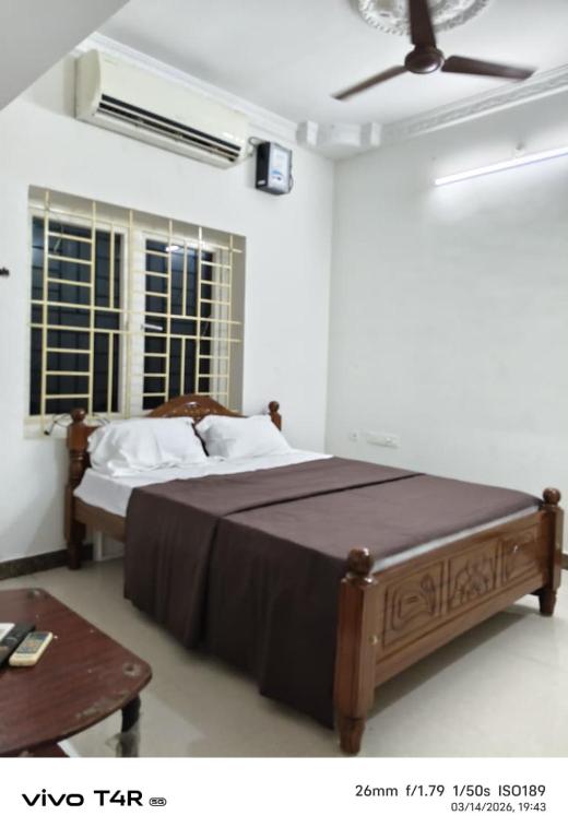 a bedroom with a large bed and a ceiling fan at Kmr villa in Madurai