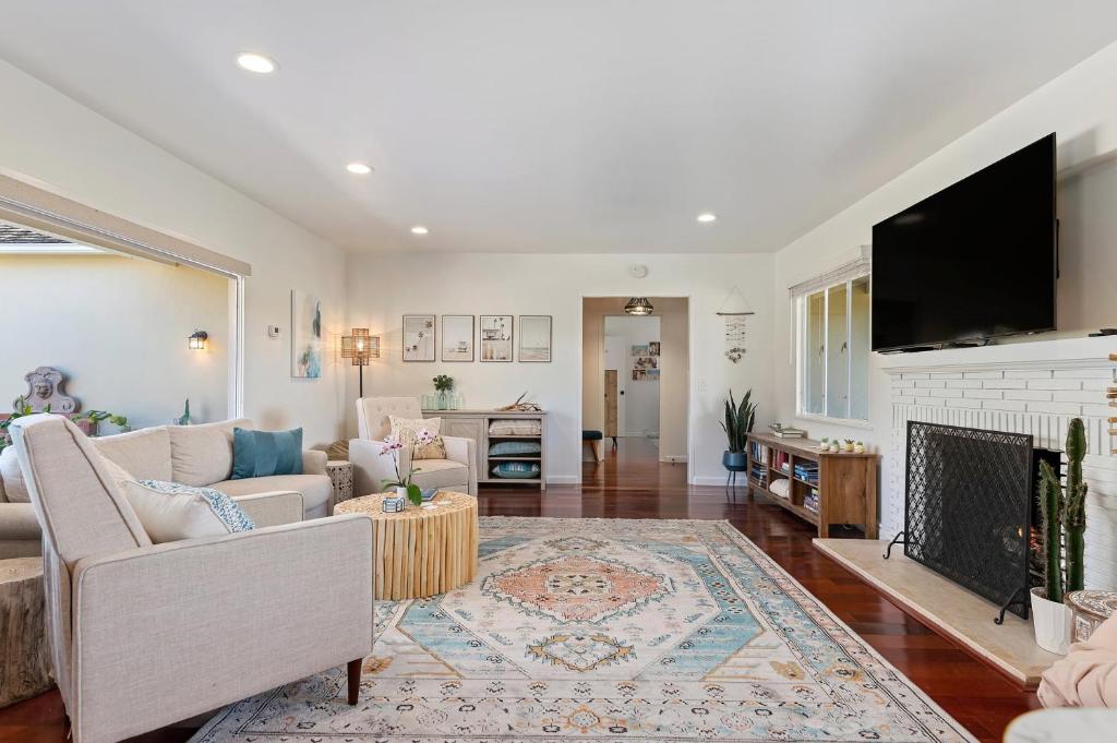 a living room with a fireplace and a tv at Bella Luna in Carpinteria