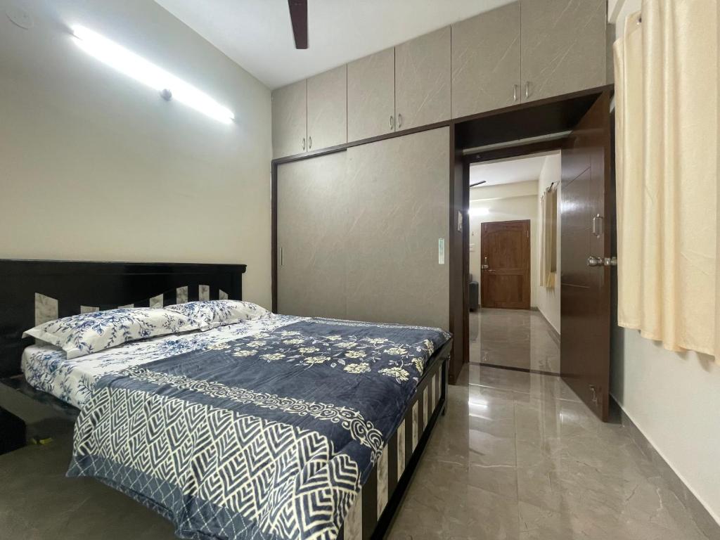 a bedroom with a bed with a blue comforter at Narayana Avenue , kondapur 2 Bhk in Hyderabad