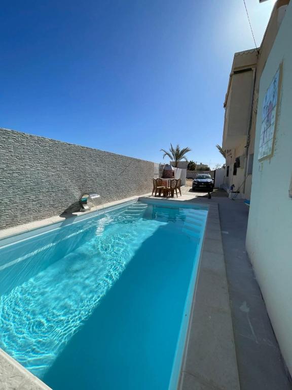 a large blue swimming pool next to a building at Dar Souleyman in Midoun