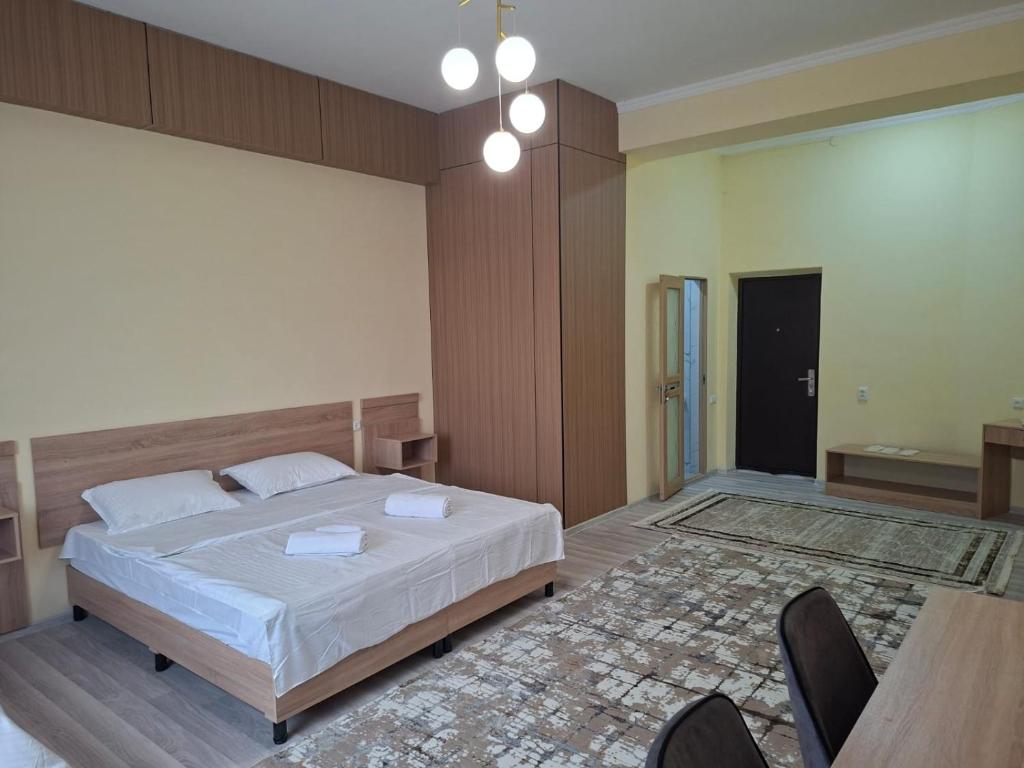 a bedroom with a bed and a table and chairs at Comfort Hotel in Almaty