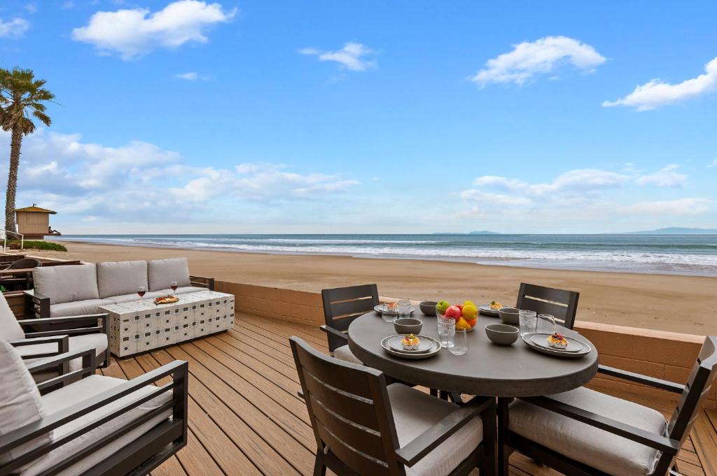 a table on a deck with a view of the beach at Carpinteria Shores CS 107 in Carpinteria