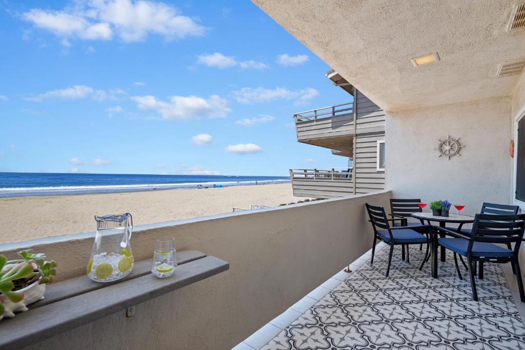 a balcony with a table and chairs and the beach at Carpinteria Shores CS 212 in Carpinteria