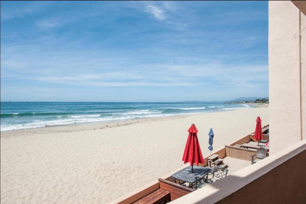a beach with chairs and umbrellas and the ocean at Carpinteria Shores CS 206 in Carpinteria