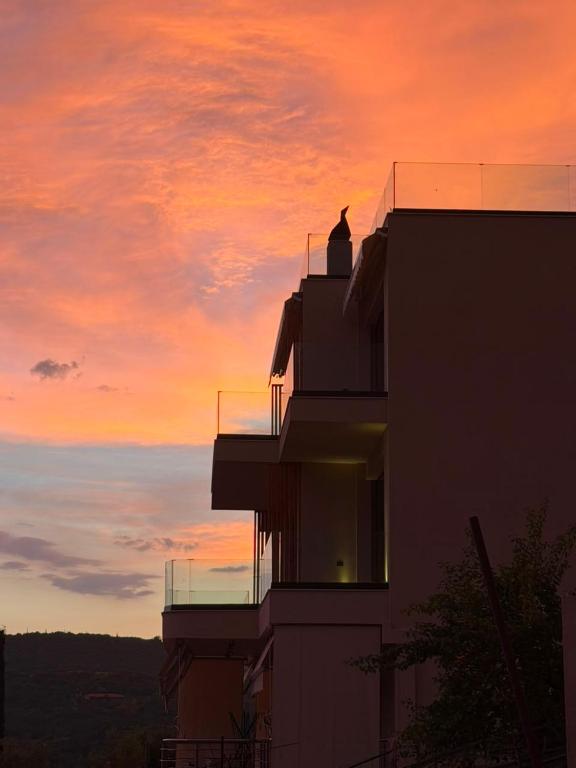 a silhouette of a building with a sunset in the background at Soléa Himara Guesthouse in Himare