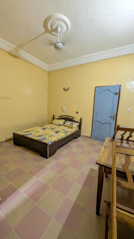 a bedroom with a bed and a table in it at Hôtel St Jo in Bohicon