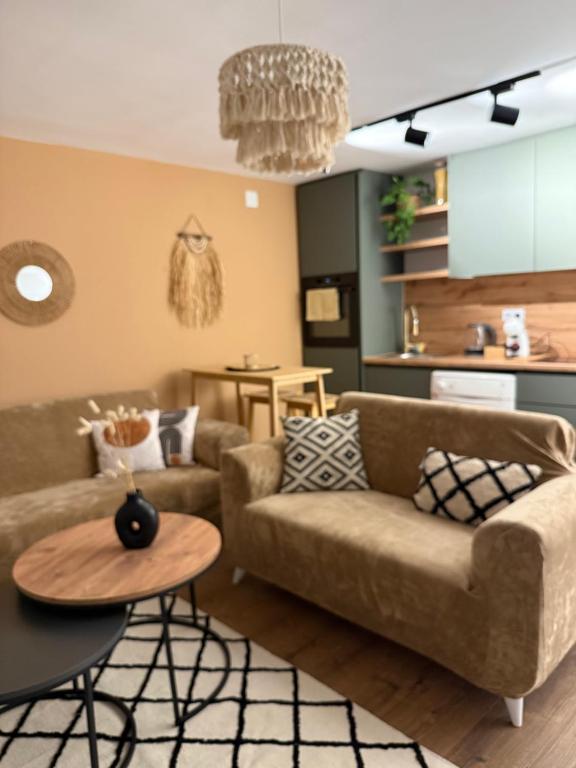 a living room with a couch and a table at Andrra Apartment in Prishtinë