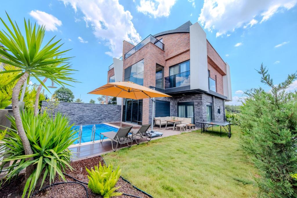 a house with a swimming pool and a patio at Luxury Forest Villas with Private Pool in Antalya