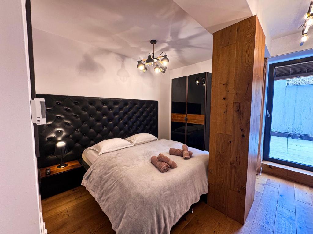 a bedroom with a large bed with a black headboard at Luxury Apartments C in Braşov