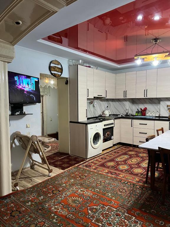 a kitchen with a washer and dryer in a room at Azamat in Kara-Koo