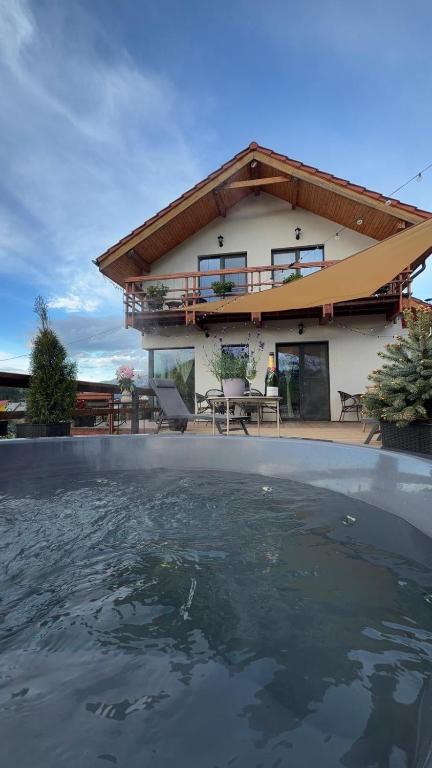 a house with a swimming pool in front of it at Casa de Sub Munte Cozy Chalet in Fundata