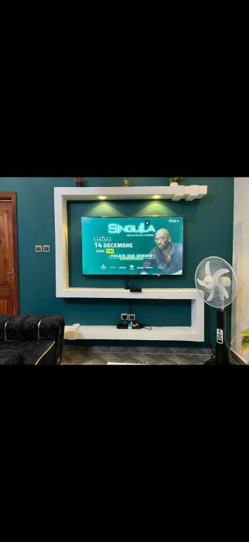 a flat screen tv sitting on top of a wall at Empereur City in Ouidah