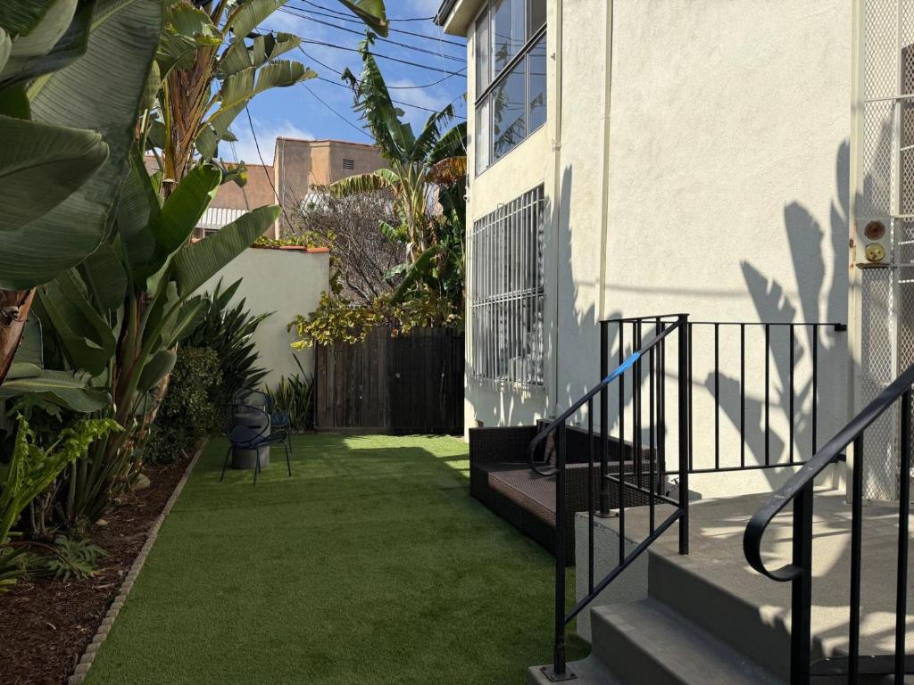 a garden with green grass next to a house at Charming 3BR Beverly Retreat with Large Private Backyard Bedford in Los Angeles