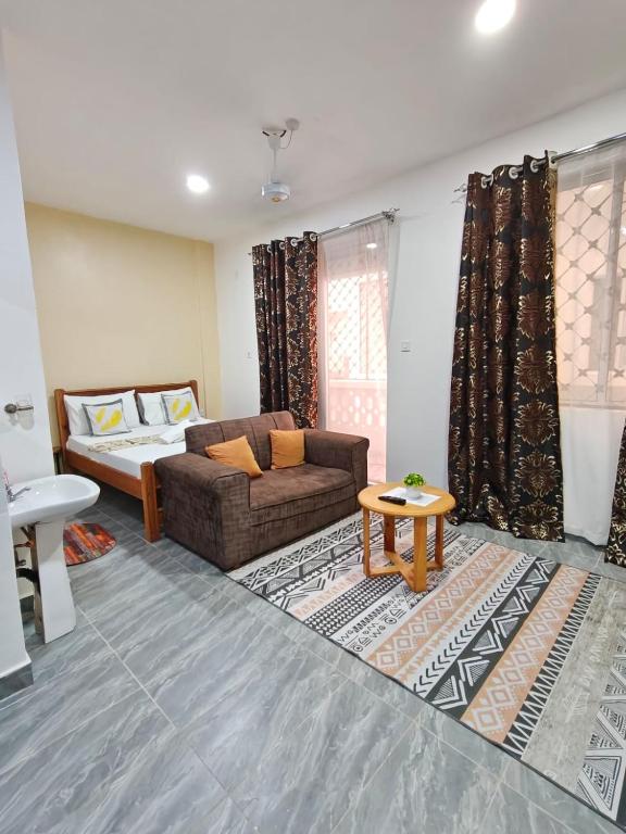 a living room with a couch and a table at Stylish Mtwapa Studio with Rooftop Pool View in Mtwapa