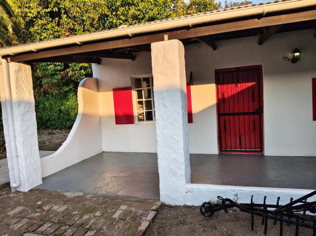 a small house with a red door and a bicycle outside at Firehouse self-catering cottage 7 in Wellington