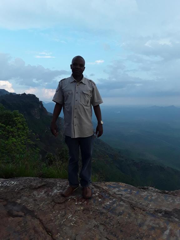 a man standing on top of a mountain at Sheiza in Kampala