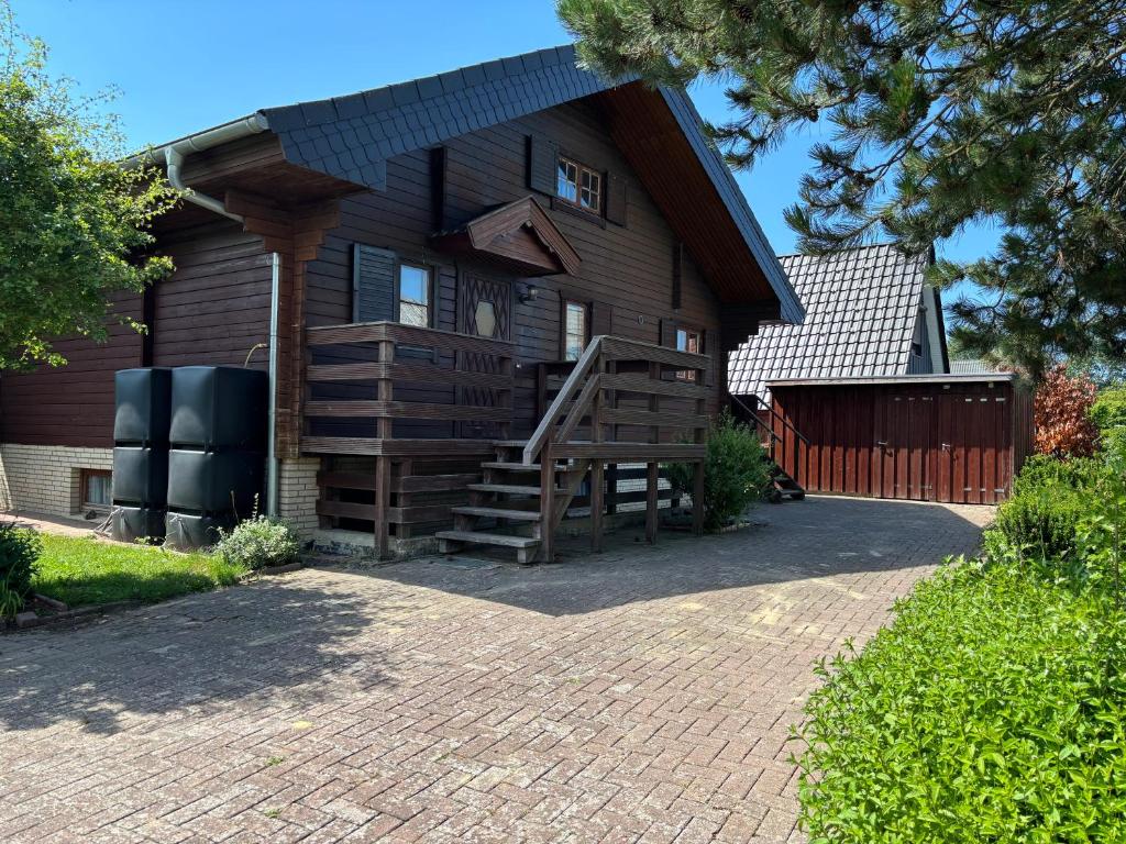 a brown house with a staircase leading up to it at Feriendomizil Haus Störtebeker in Spieka-Neufeld