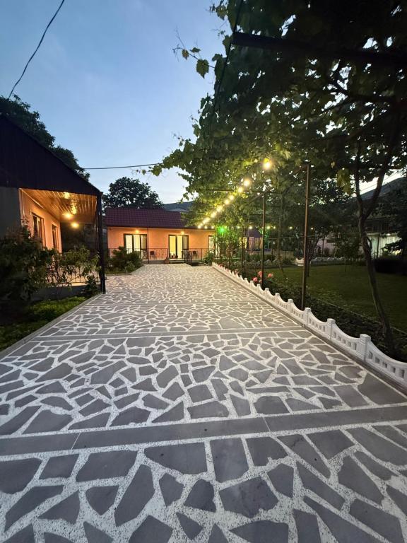 a cobblestone driveway with lights in front of a building at Tsiskari Guesthouse in Vardzia