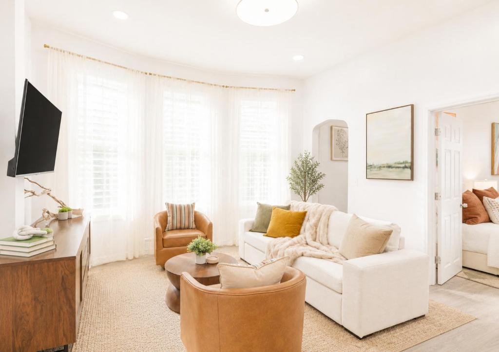 a white living room with a white couch and chairs at The Harper Loft near Manhattan with NYC skyline view in Hoboken