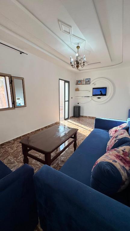 a living room with a blue couch and a coffee table at Sidi kaouki Private House in Sidi Kaouki