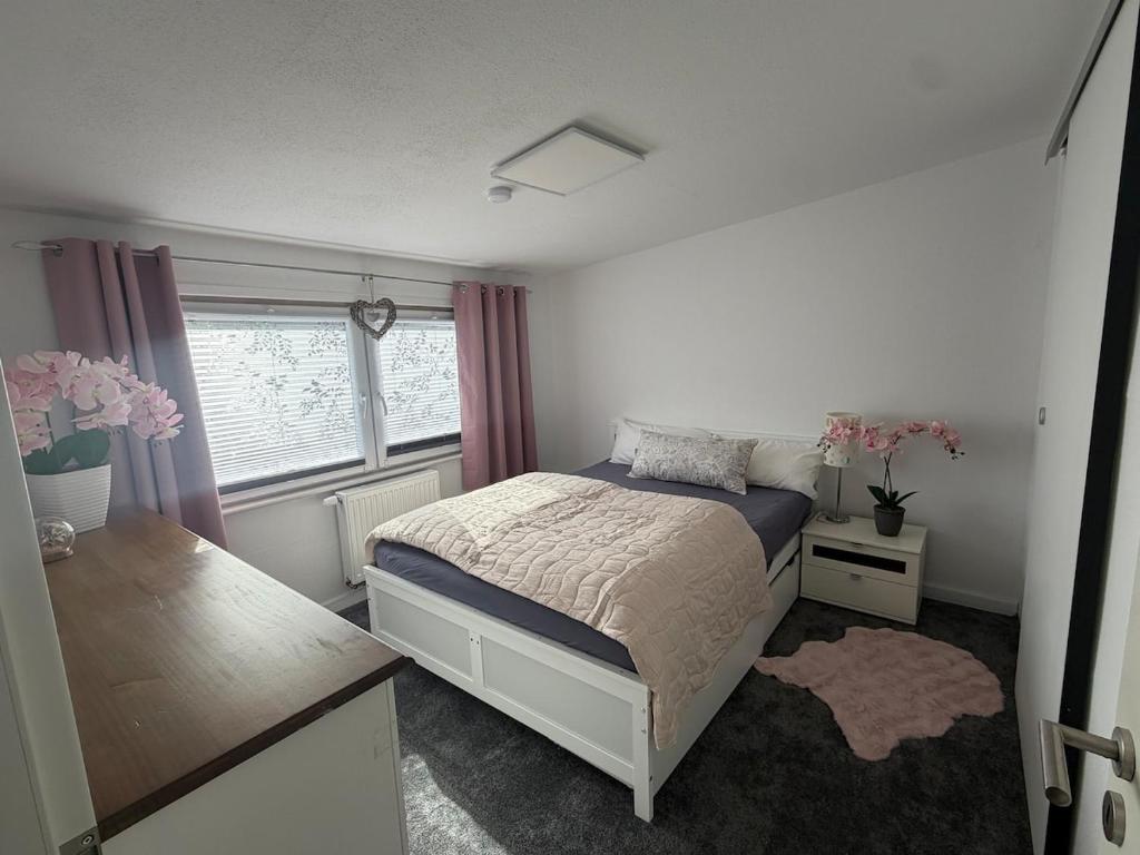 a bedroom with a bed and a desk with flowers at Annas Ruheoase in Meißendorf