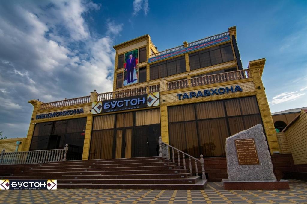 a large yellow building with stairs in front of it at Hotel Buston in Chkalovsk