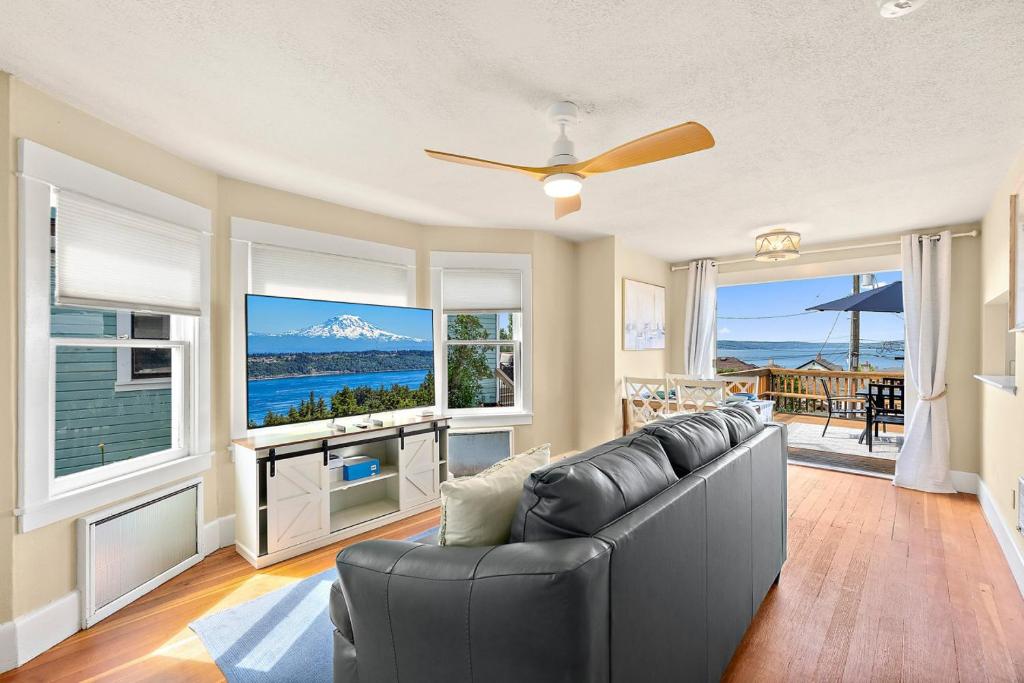 a living room with a couch and large windows at Old Tacoma Victorian Main Floor Duplex Unit in Tacoma