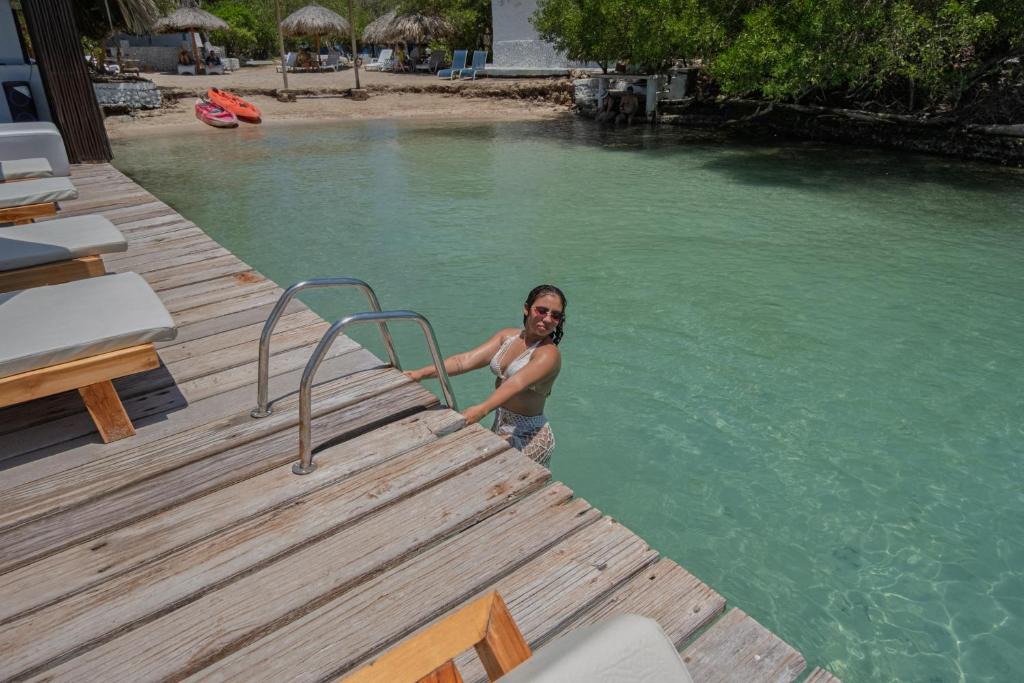 a man standing on a dock in a swimming pool at Bayside Island in Cartagena de Indias