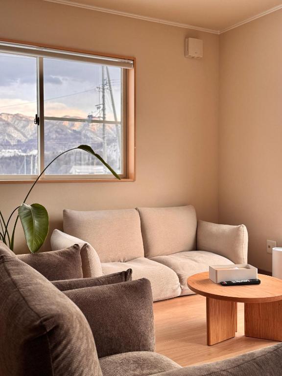 a living room with a couch and a table at Yamamori House in Hakuba