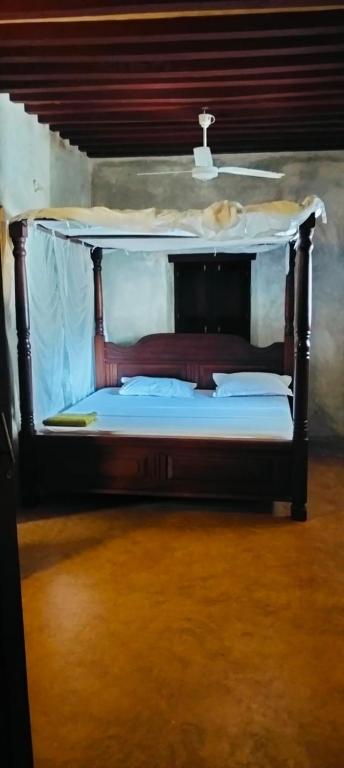 a bed with a canopy in a room at Lola House in Lamu